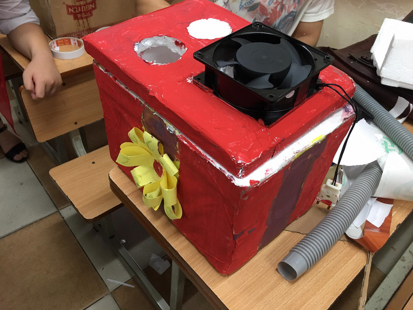 A red box with a fan on top

Description automatically generated