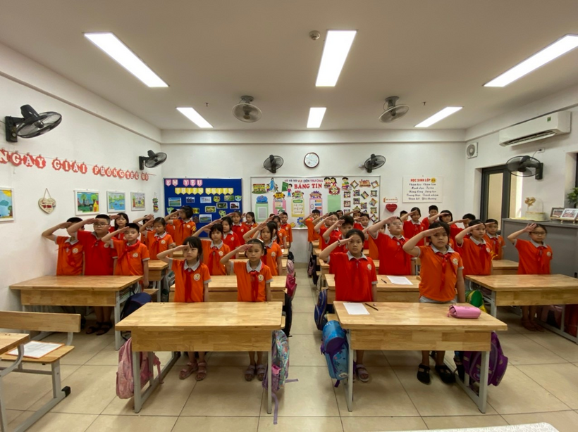 A group of children in a classroom saluting

Description automatically generated