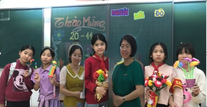 A group of women standing in front of a chalkboard

Description automatically generated