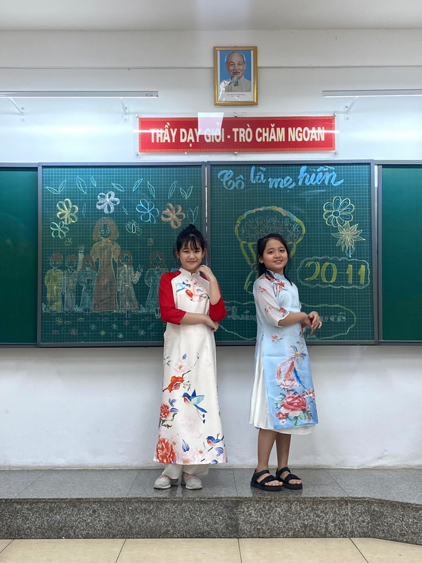 Two girls standing in front of a chalkboard

Description automatically generated